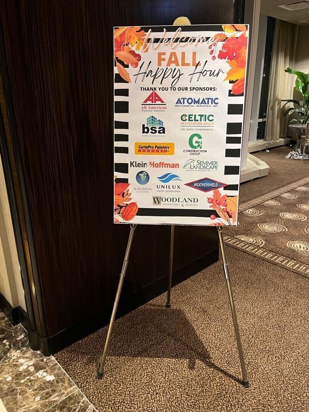 A sign for a fall happy hour is sitting on a metal easel.