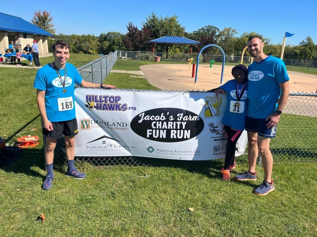 A group of people standing in front of a charity fun run banner.