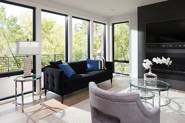 A living room with a black couch and a fireplace