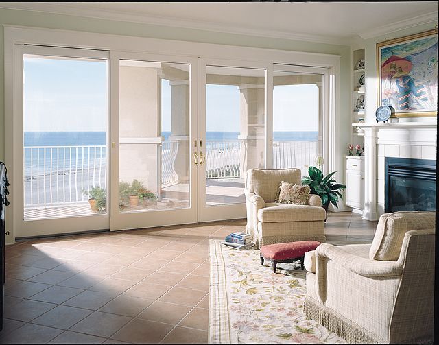 A living room with sliding glass doors leading to a balcony overlooking the ocean