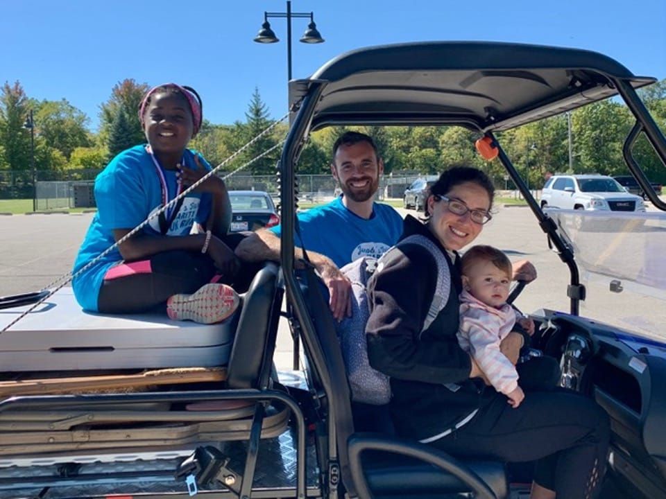 A group of people are sitting in a golf cart.