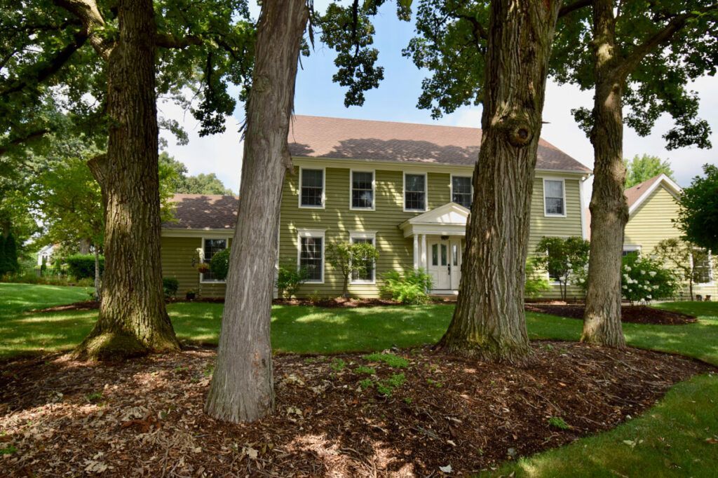 A house with a lot of trees in front of it