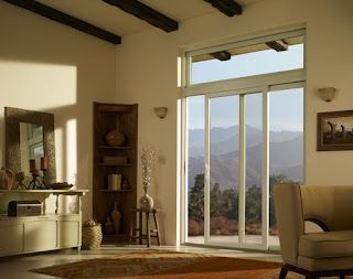 A living room with a couch , chair and sliding glass doors.