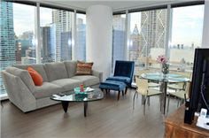 A living room with a couch , chairs , table and television.