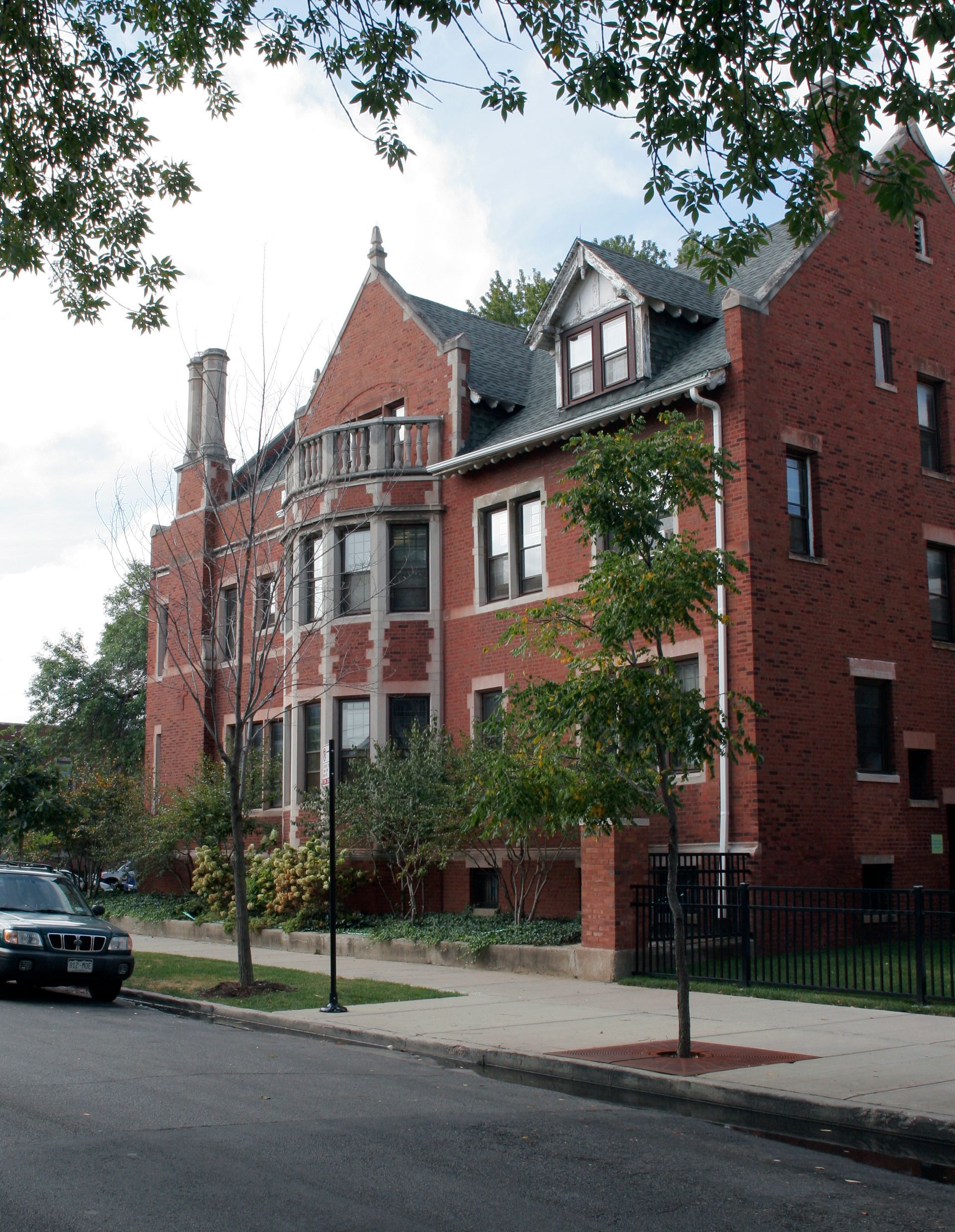 A large red brick building with a car parked in front of it