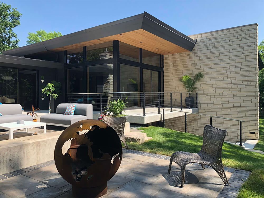 A modern house with a patio area in front of it.