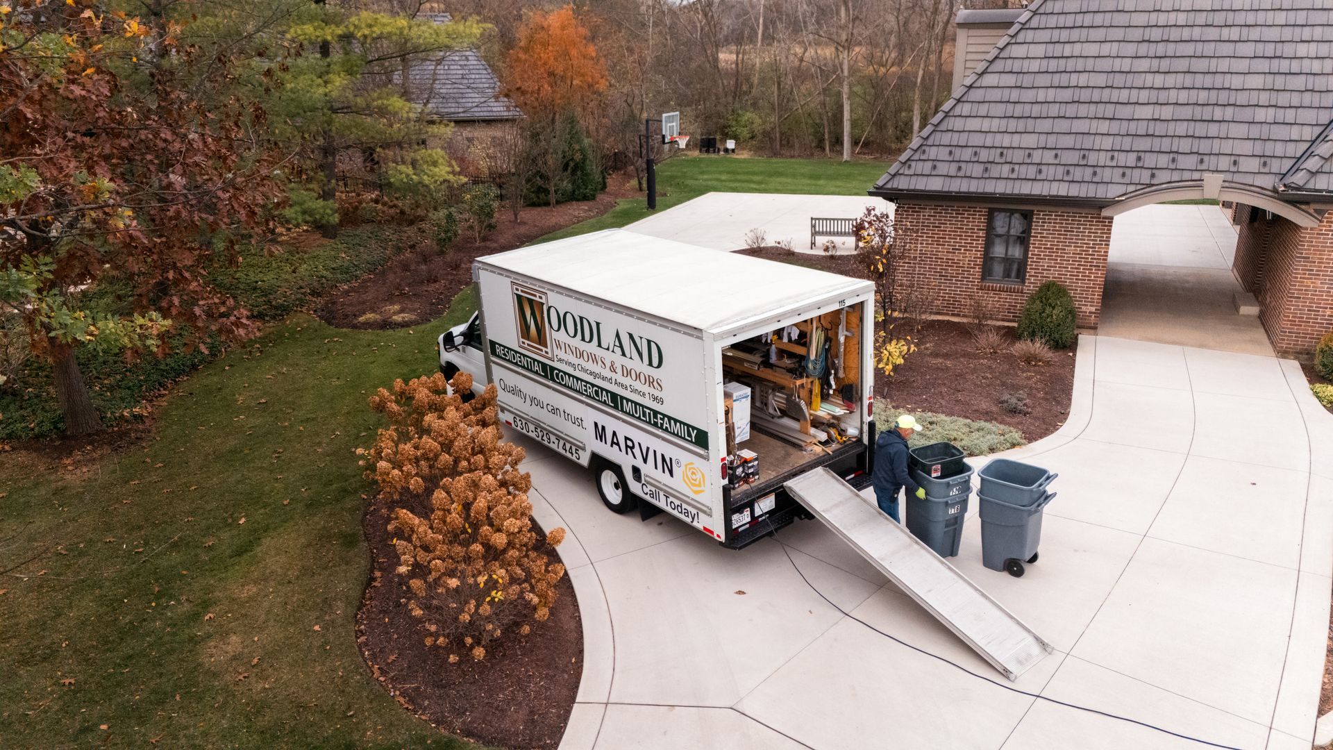 A living room with a couch , chair , table and sliding glass doors leading to a porch.