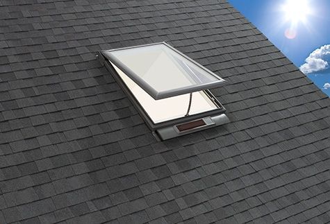 A skylight on top of a roof with the sun shining through it.