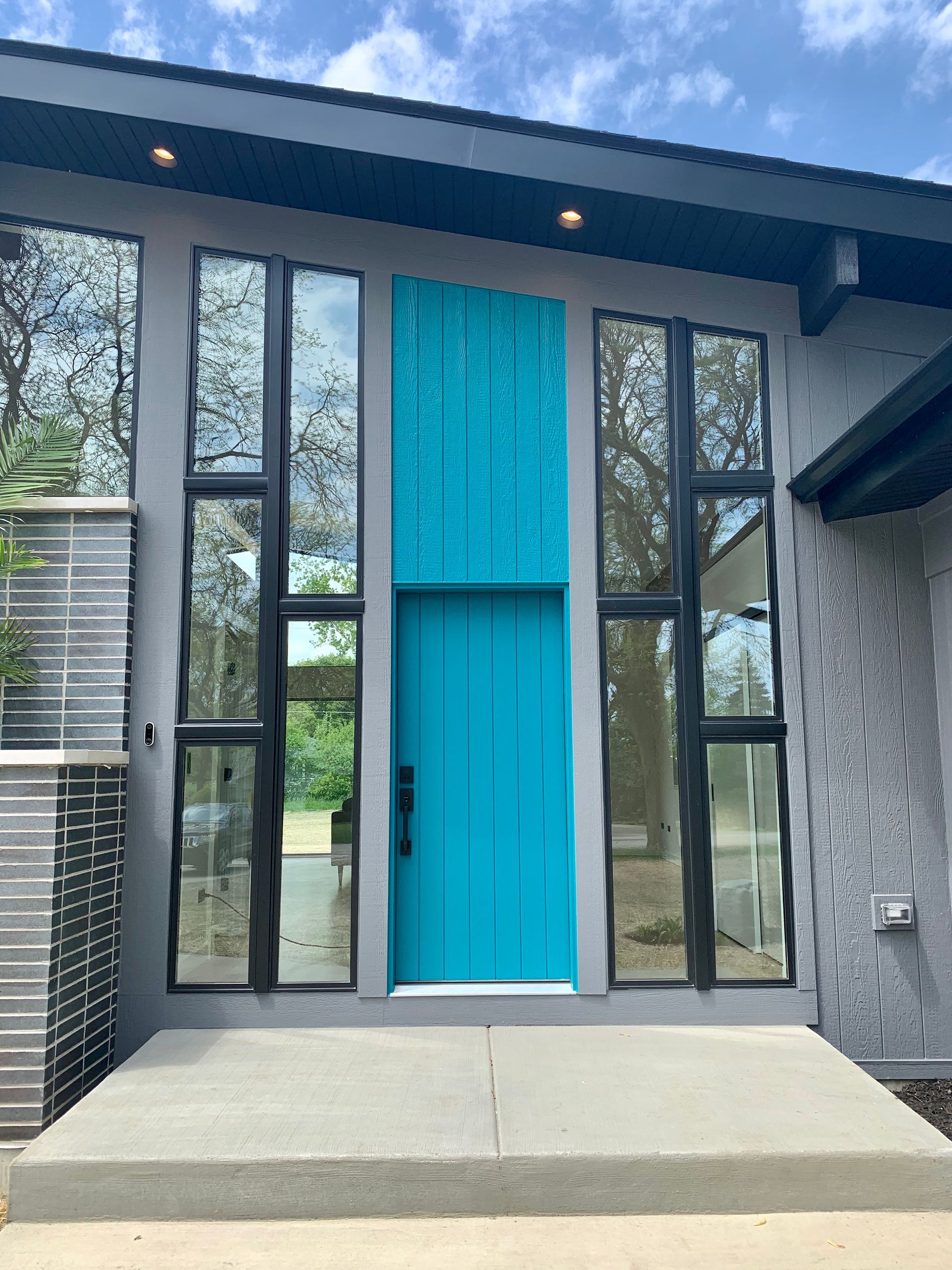 A house with a blue door and lots of windows