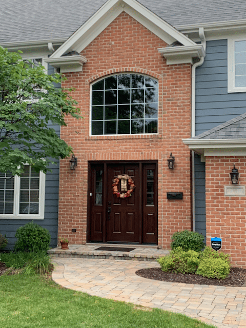 The front door of a brick house with a wreath on it