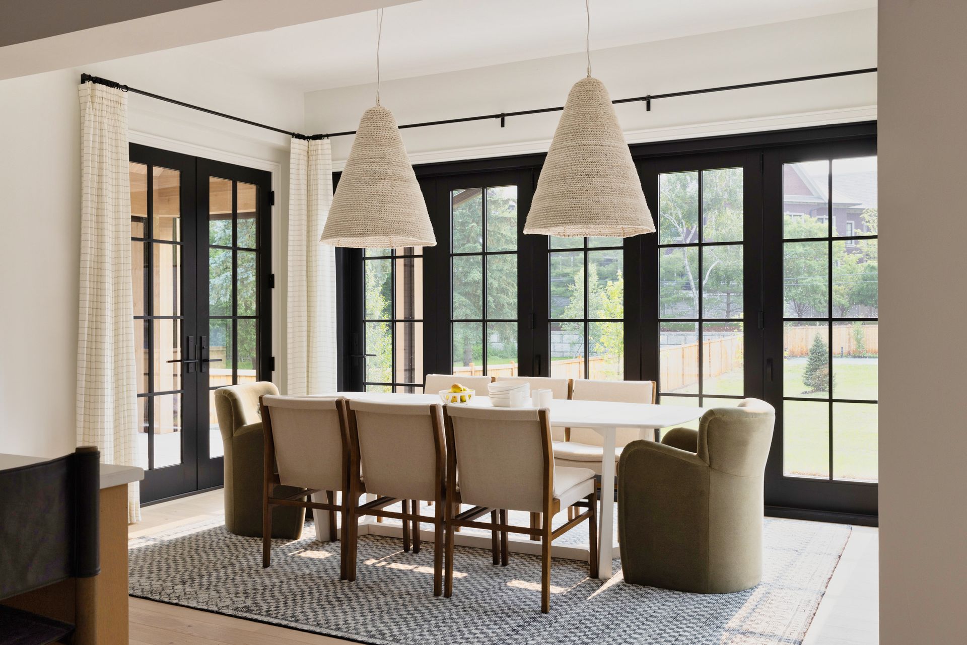 A dining room with a table and chairs and a rug.