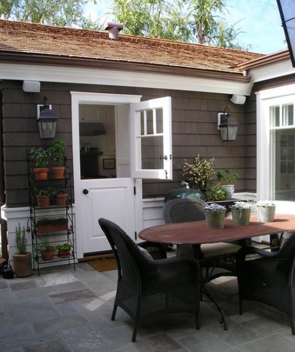 A patio with a table and chairs in front of a house