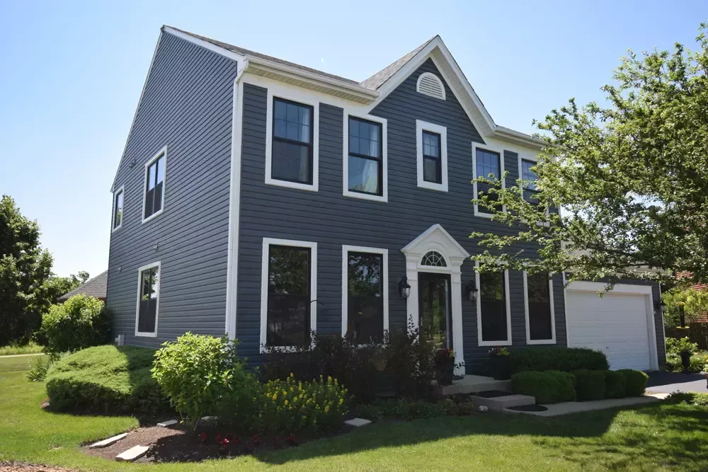A large house with a lot of windows and a white garage door