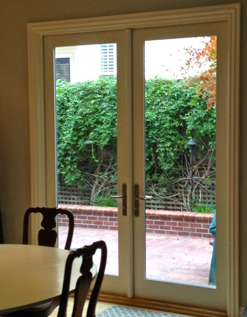 A dining room with a table and chairs and a sliding glass door