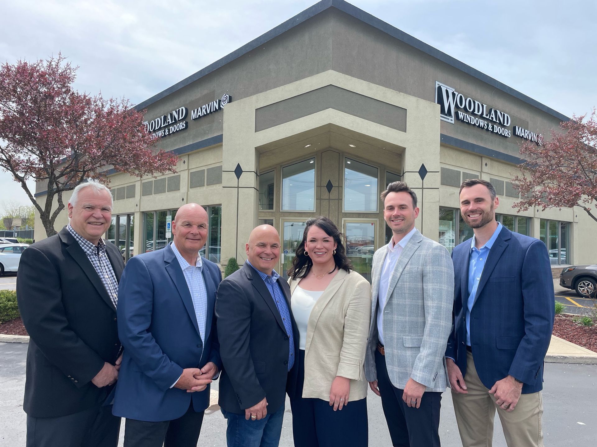 A man is getting out of a white car in front of a house.