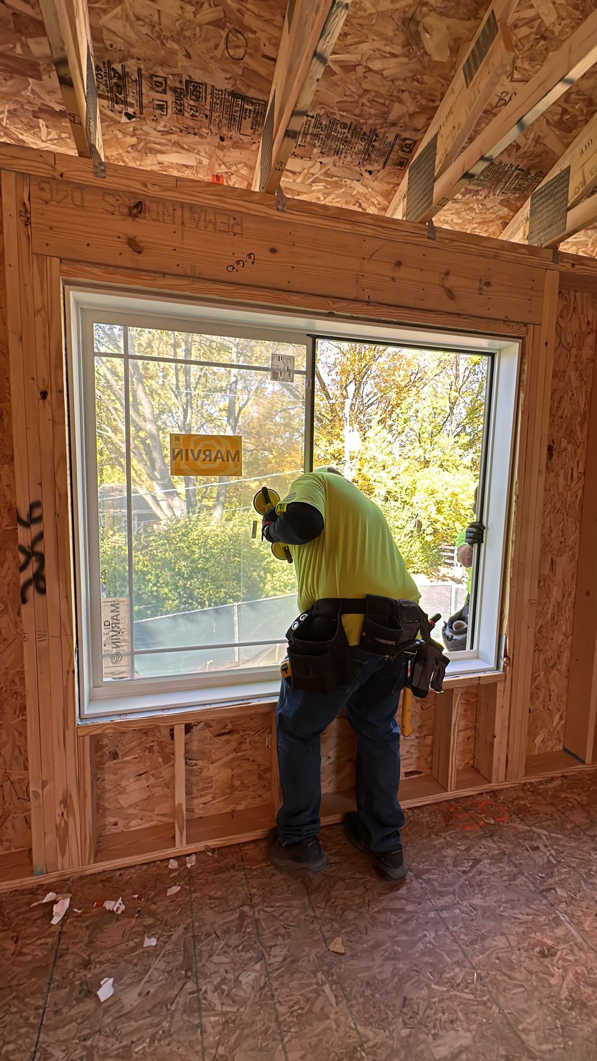 A man is installing a window in a house.