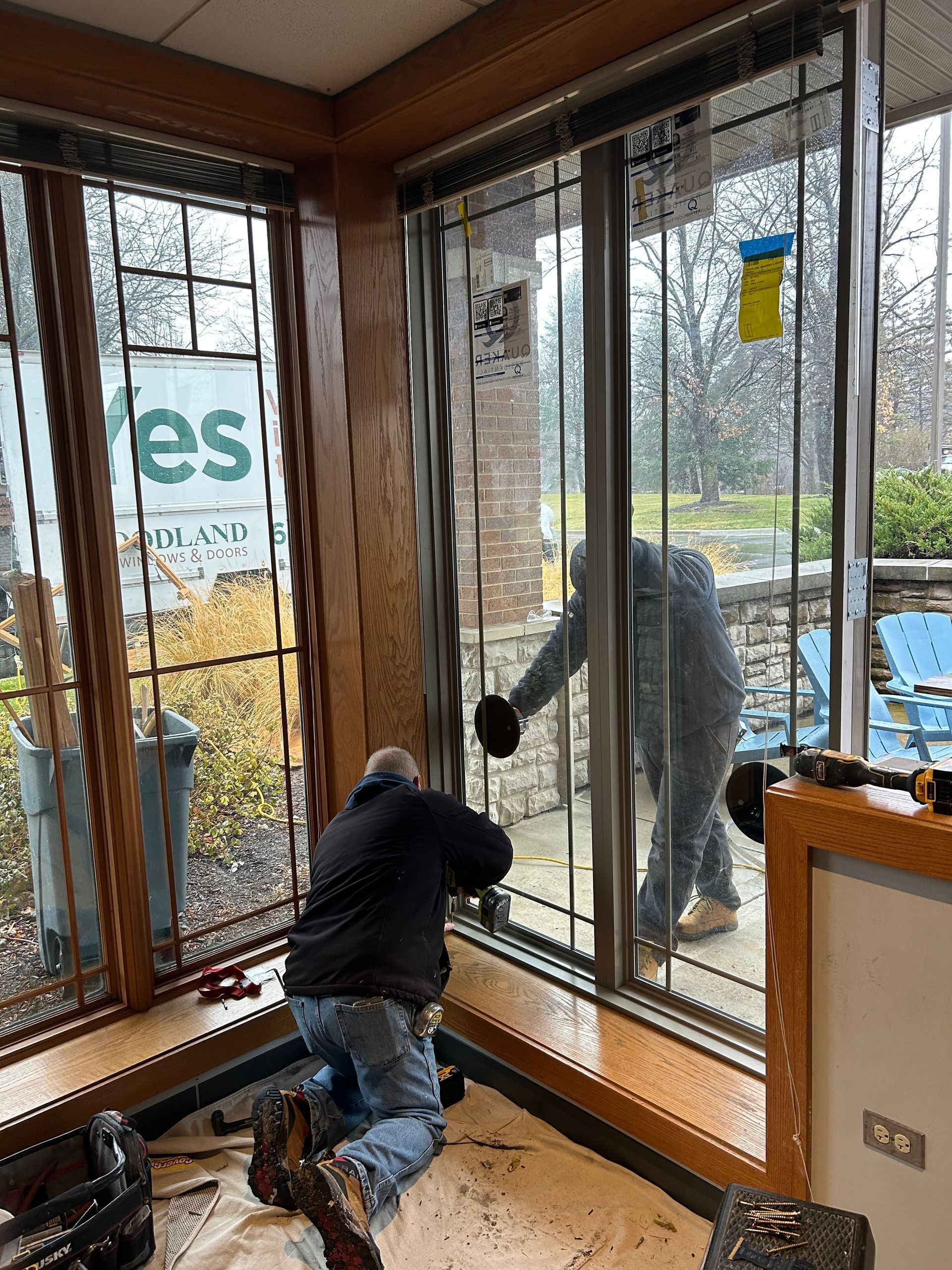 A man is installing a glass door in a room.
