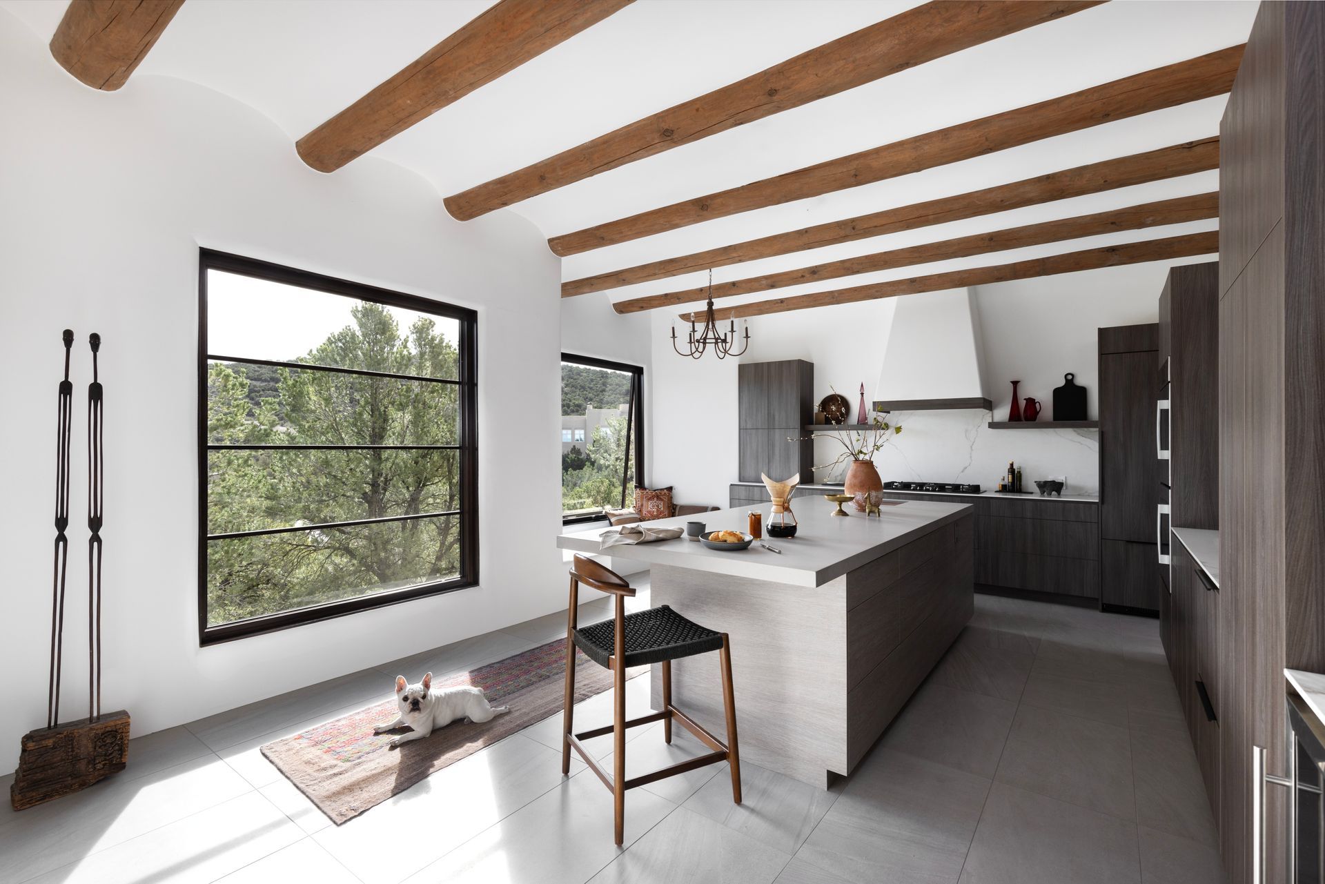 A kitchen with a large island and wooden beams on the ceiling