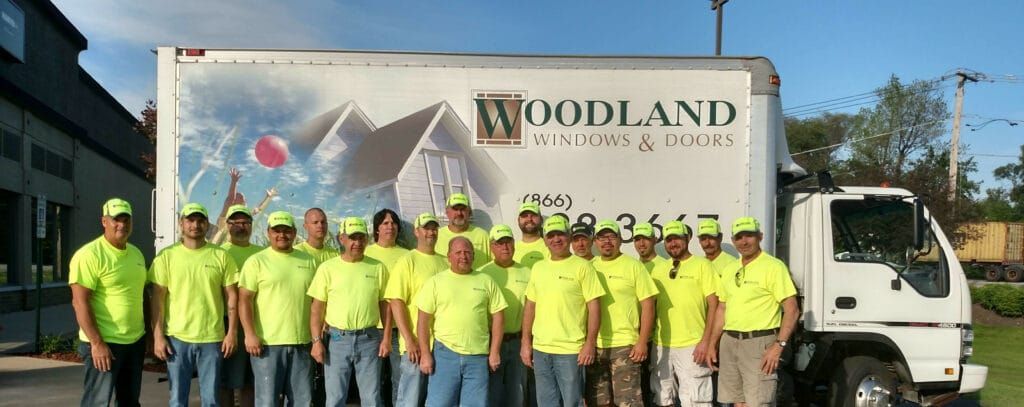 A group of men are posing for a picture in front of a woodland truck.