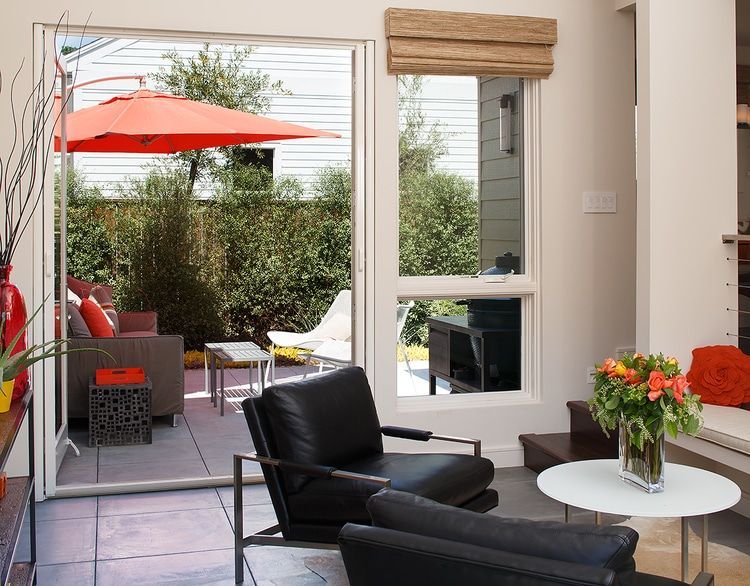 A living room with chairs a table and an umbrella