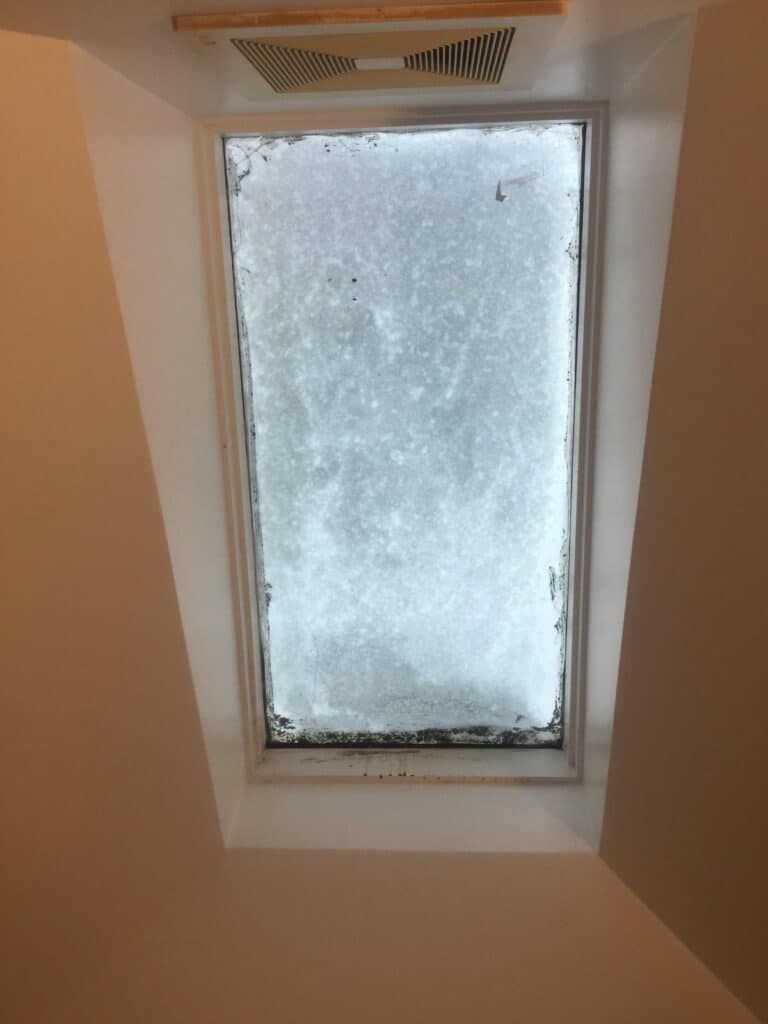 A skylight with snow on it in a room.