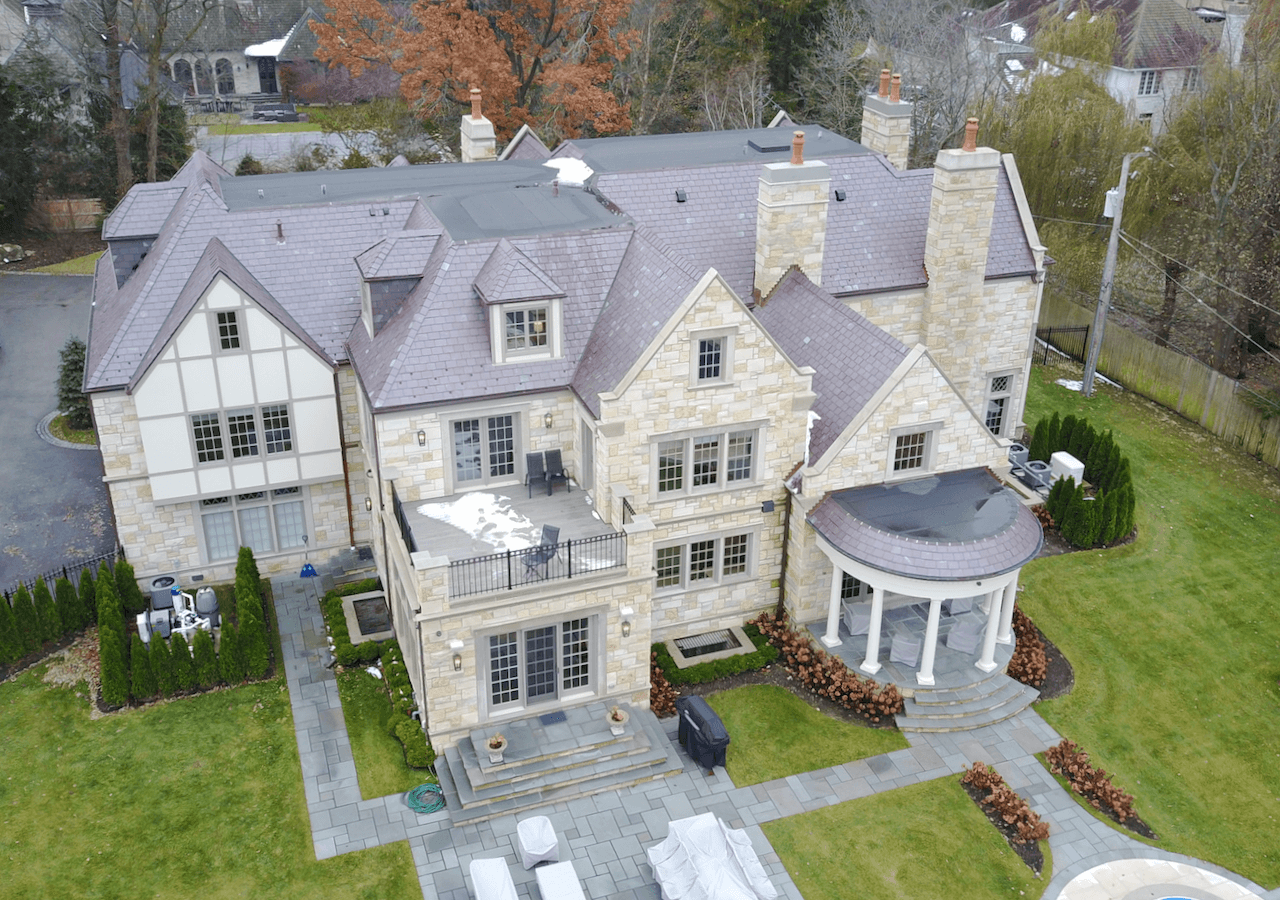 An aerial view of a large house with a large lawn in front of it.