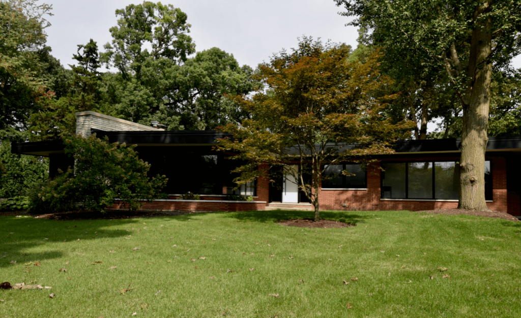 A brick house with a large lawn in front of it