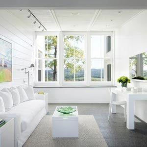 A living room with a white couch , table and chairs.