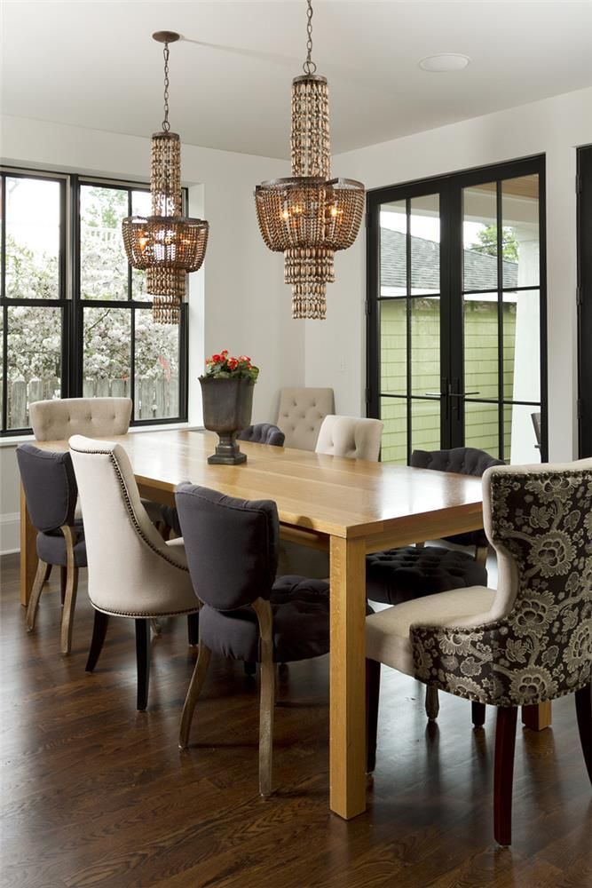 A dining room with a table and chairs and a chandelier hanging from the ceiling.