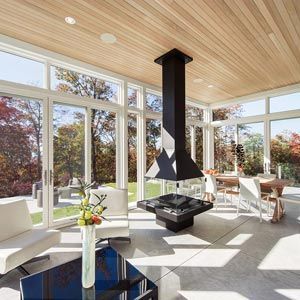 A living room with a fireplace and lots of windows.