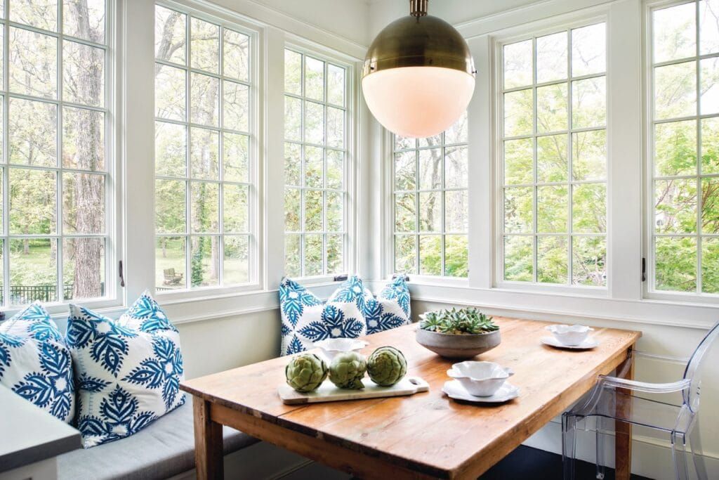 A dining room with a wooden table and a window seat.