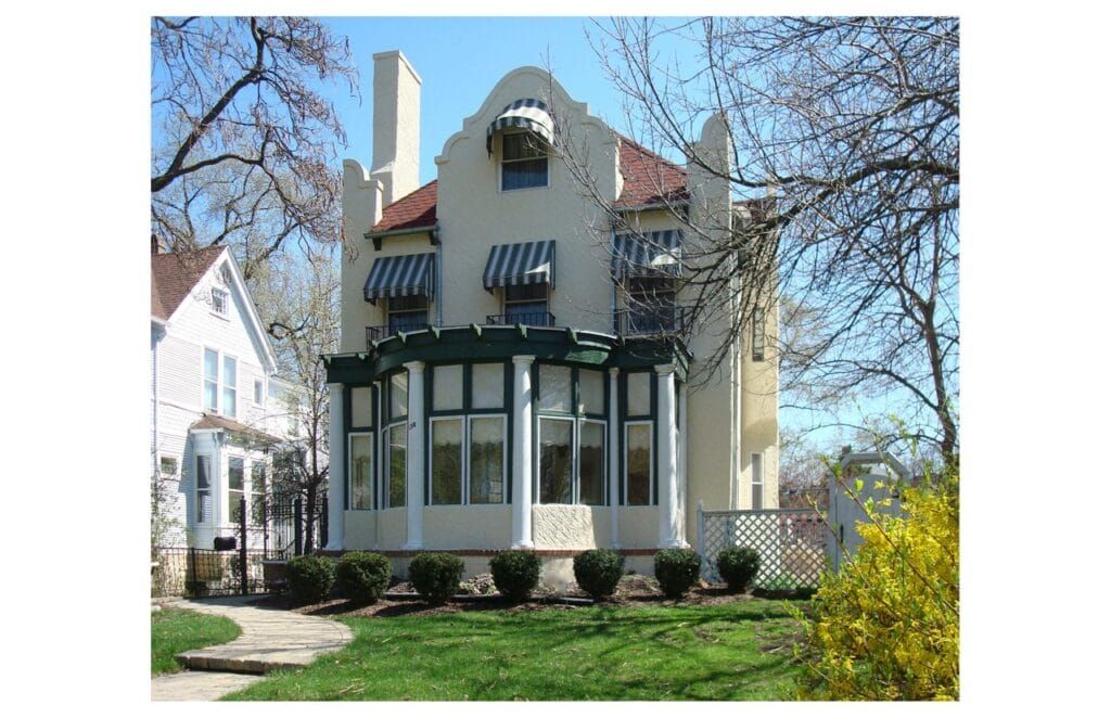 A large white house with green awnings on the windows