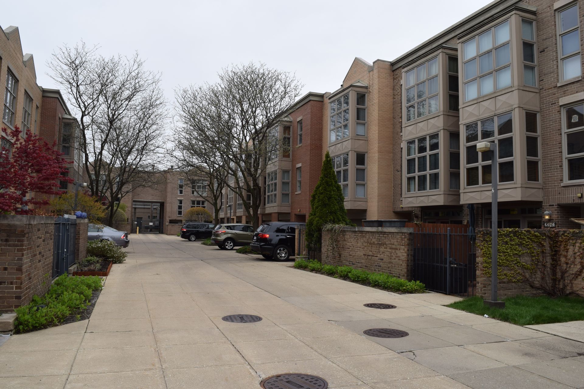 A row of apartment buildings with cars parked in front of them