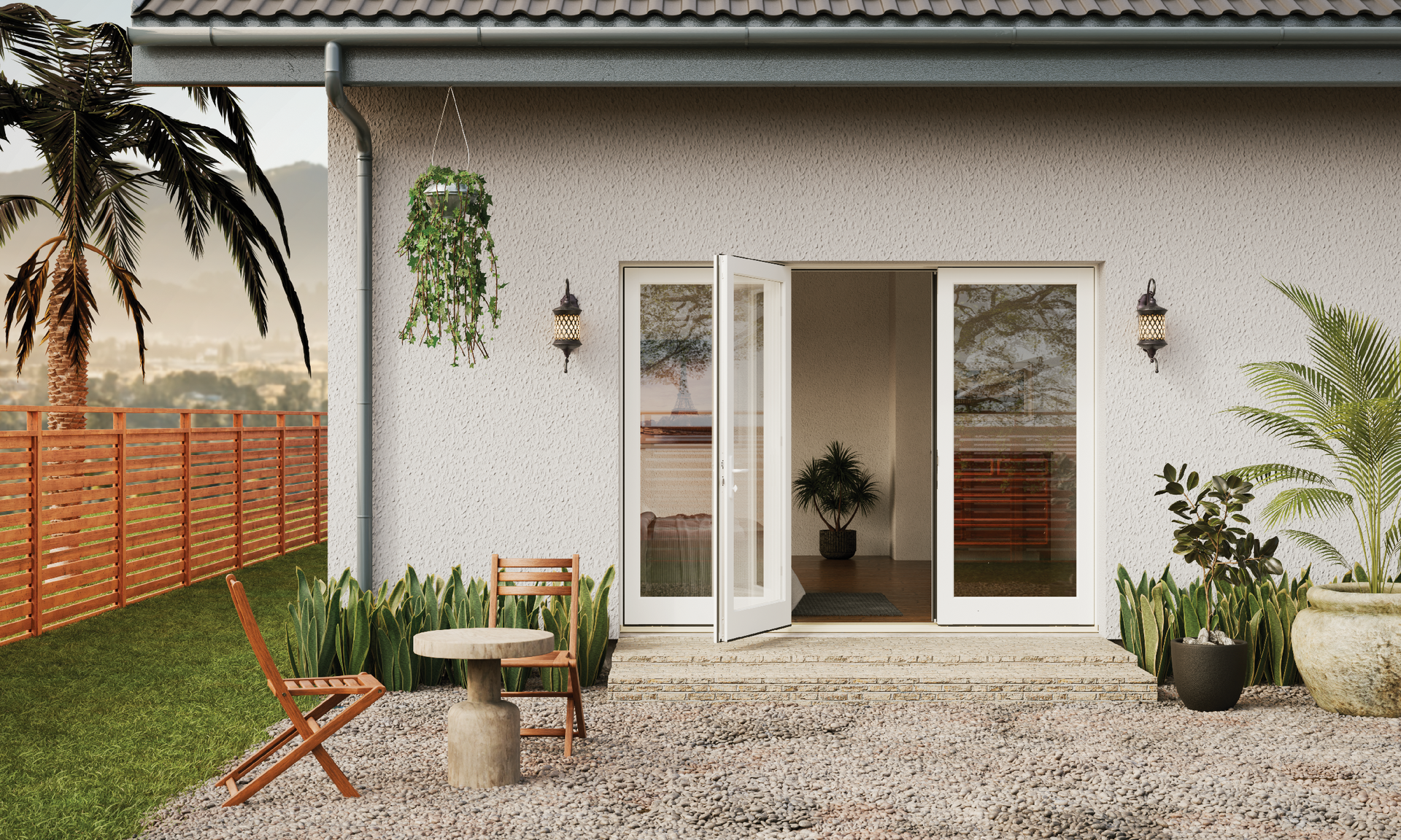 A white house with a patio with a table and chairs in front of it.