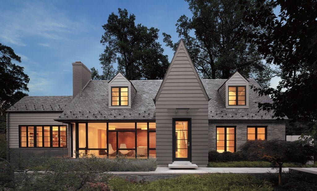 A large house with a lot of windows is lit up at night