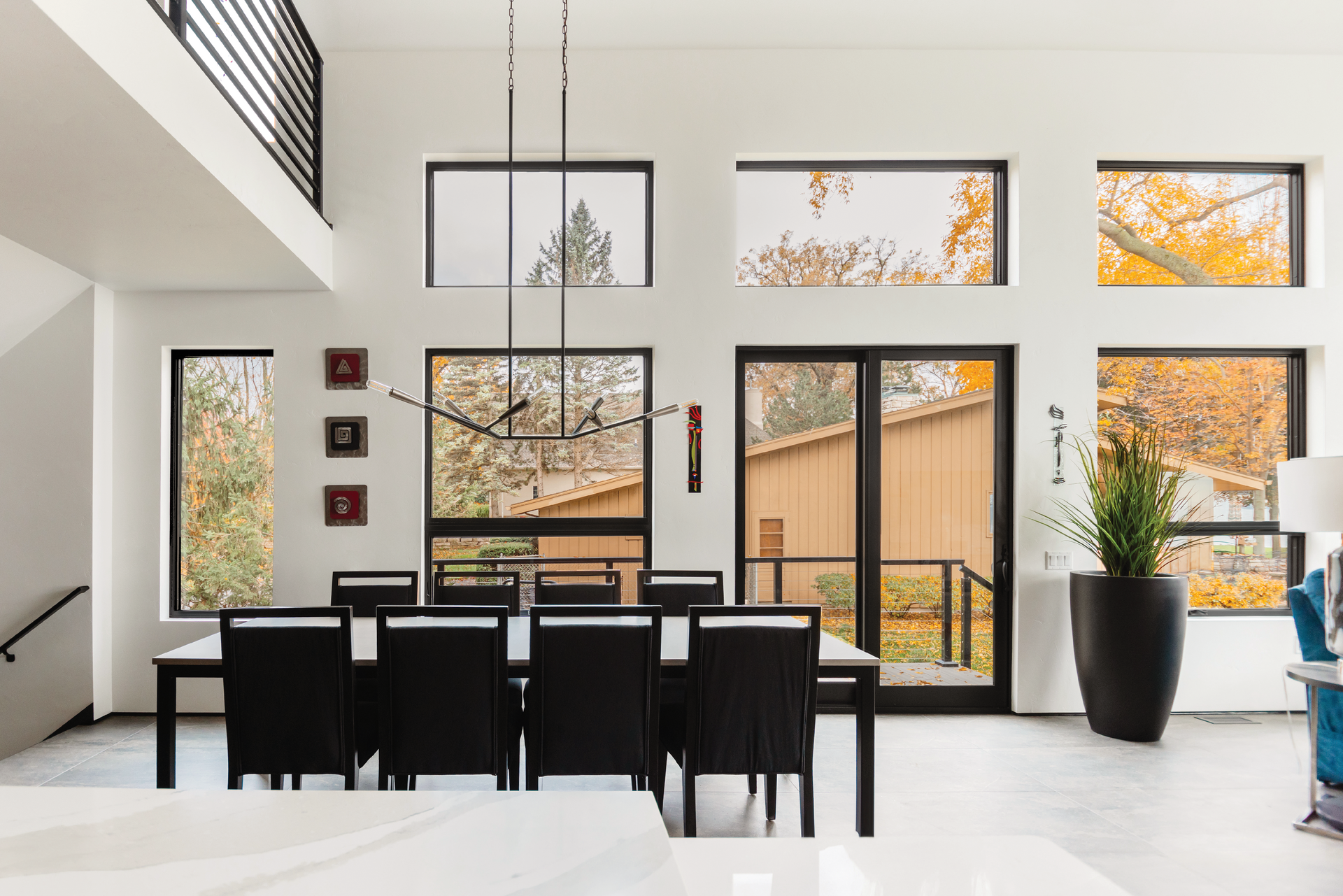 A dining room with a table and chairs and a lot of windows.