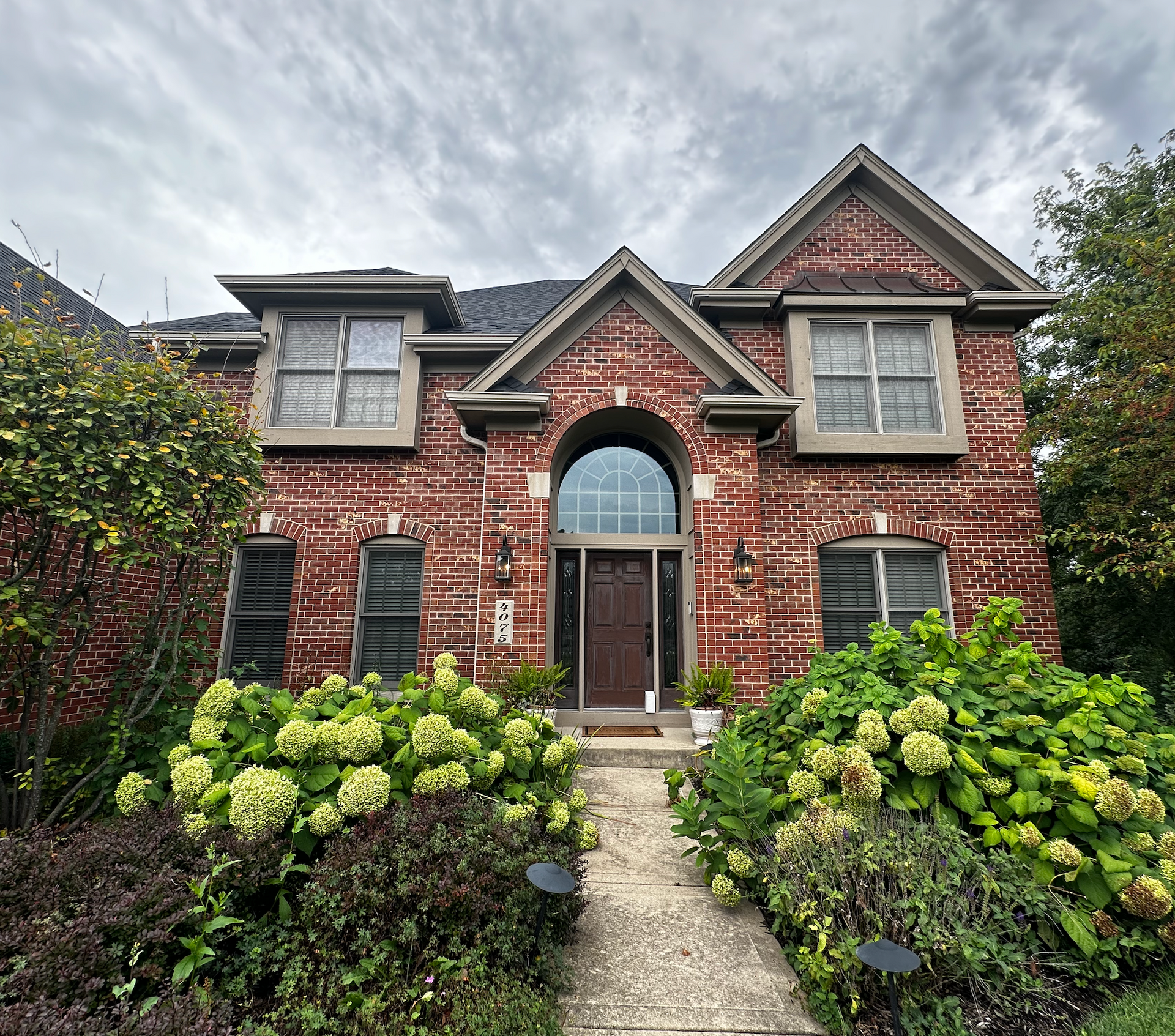 A large brick house with a walkway leading to it