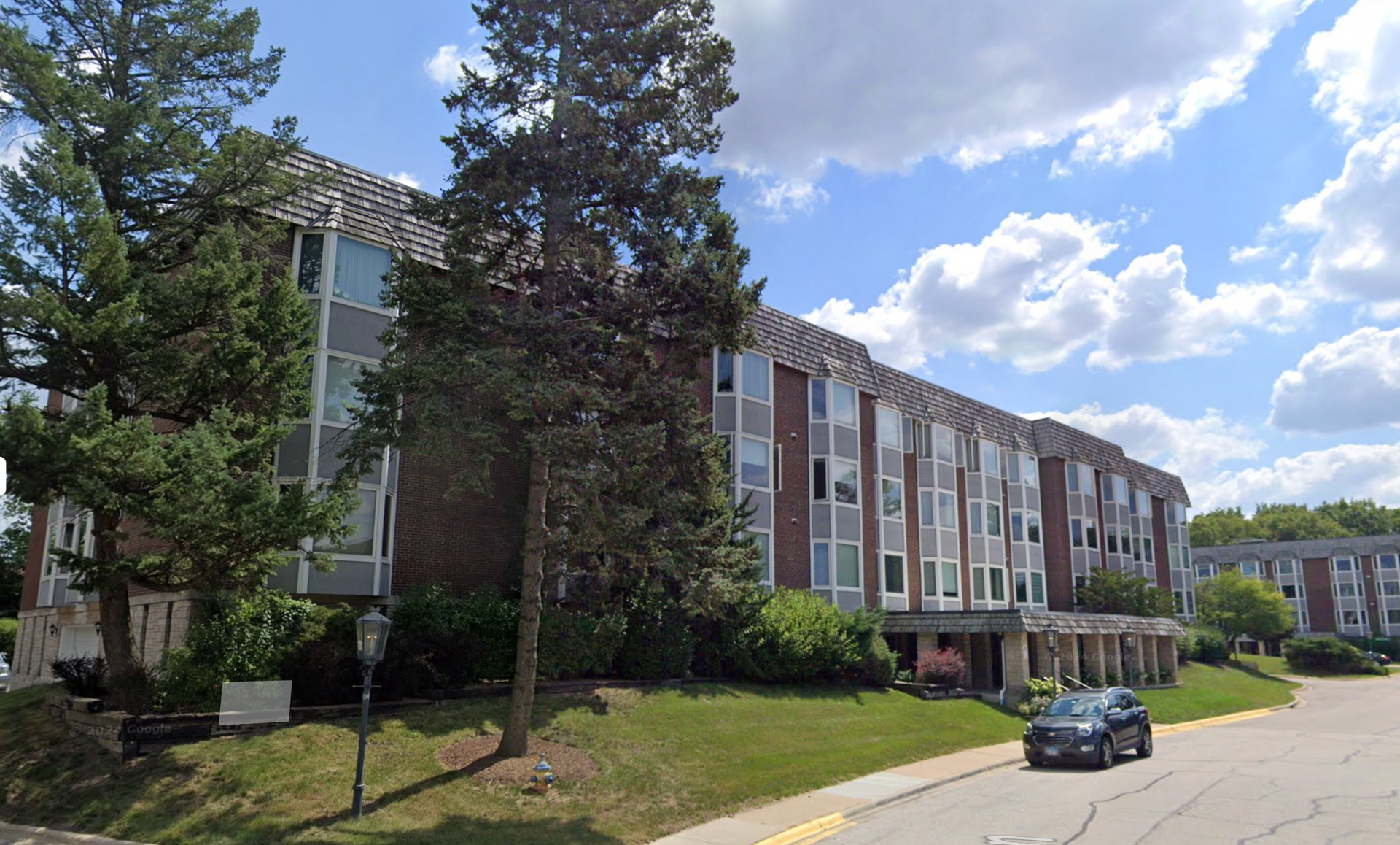 An aerial view of a building with cars parked in front of it