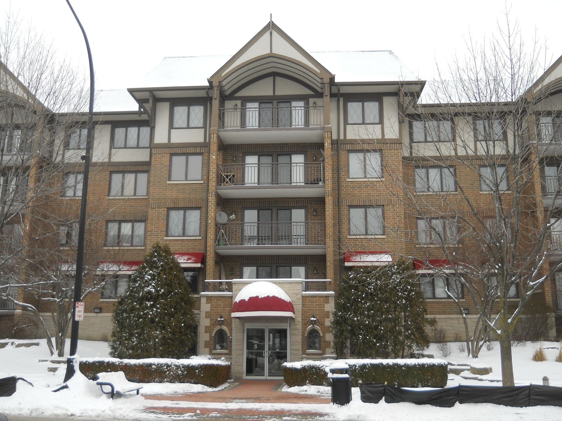 A large brick building with a red awning over the entrance