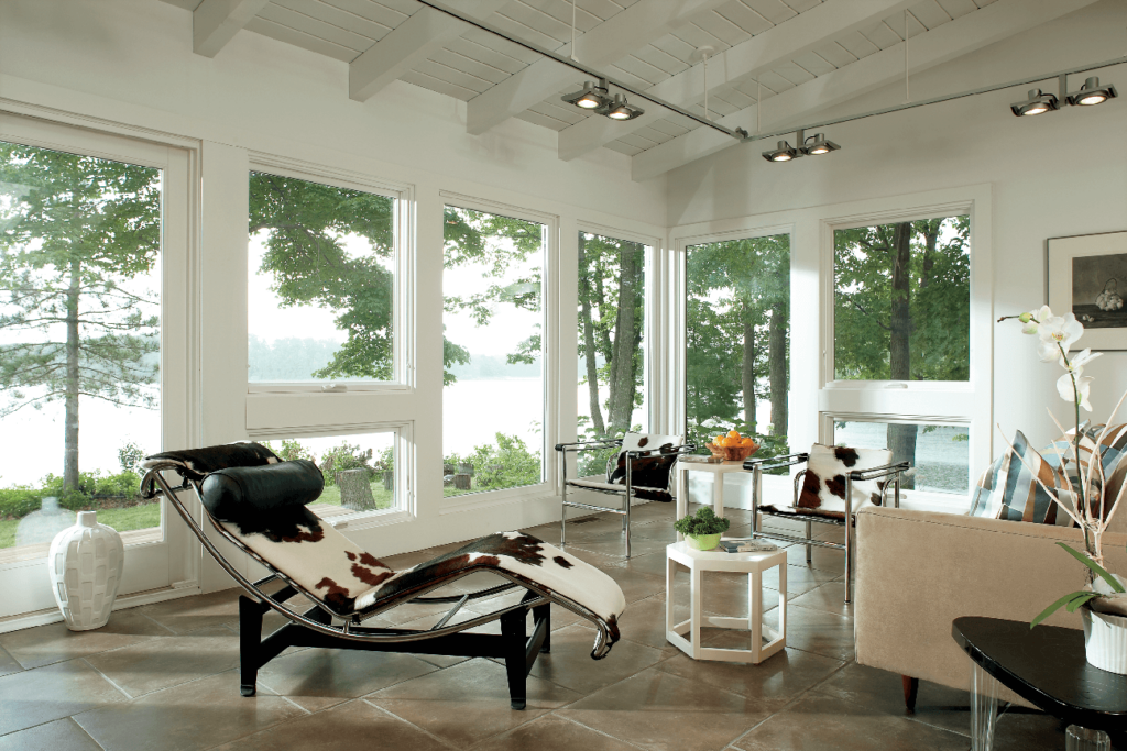 A living room with a lot of windows and a chair