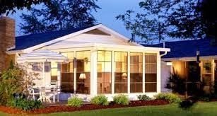 A white house with a blue roof and a screened in porch.