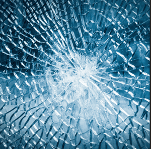 A close up of a broken glass window with a hole in it