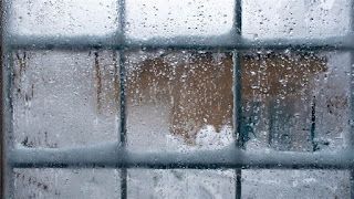 A close up of a window with water drops on it.