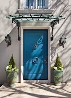 A blue door with a glass canopy over it is on the side of a building.