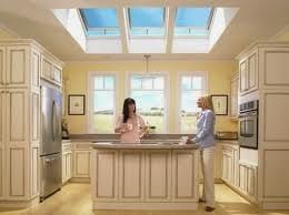 Two women are standing in a kitchen with skylights.