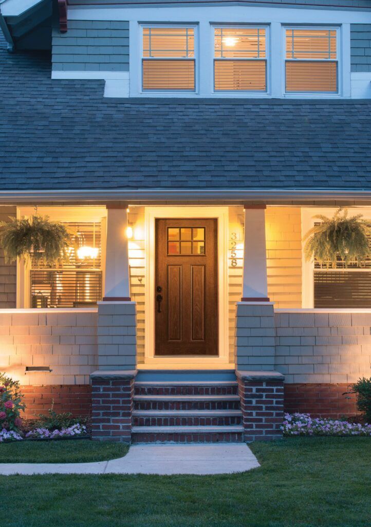 The front door of a house is lit up at night.