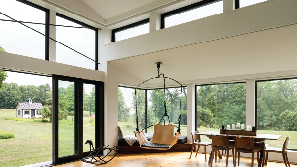 A patio with a couch and chairs and a large window