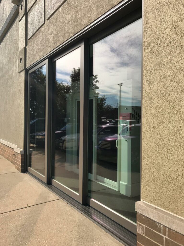 A building with a lot of windows and a parking lot in front of it.