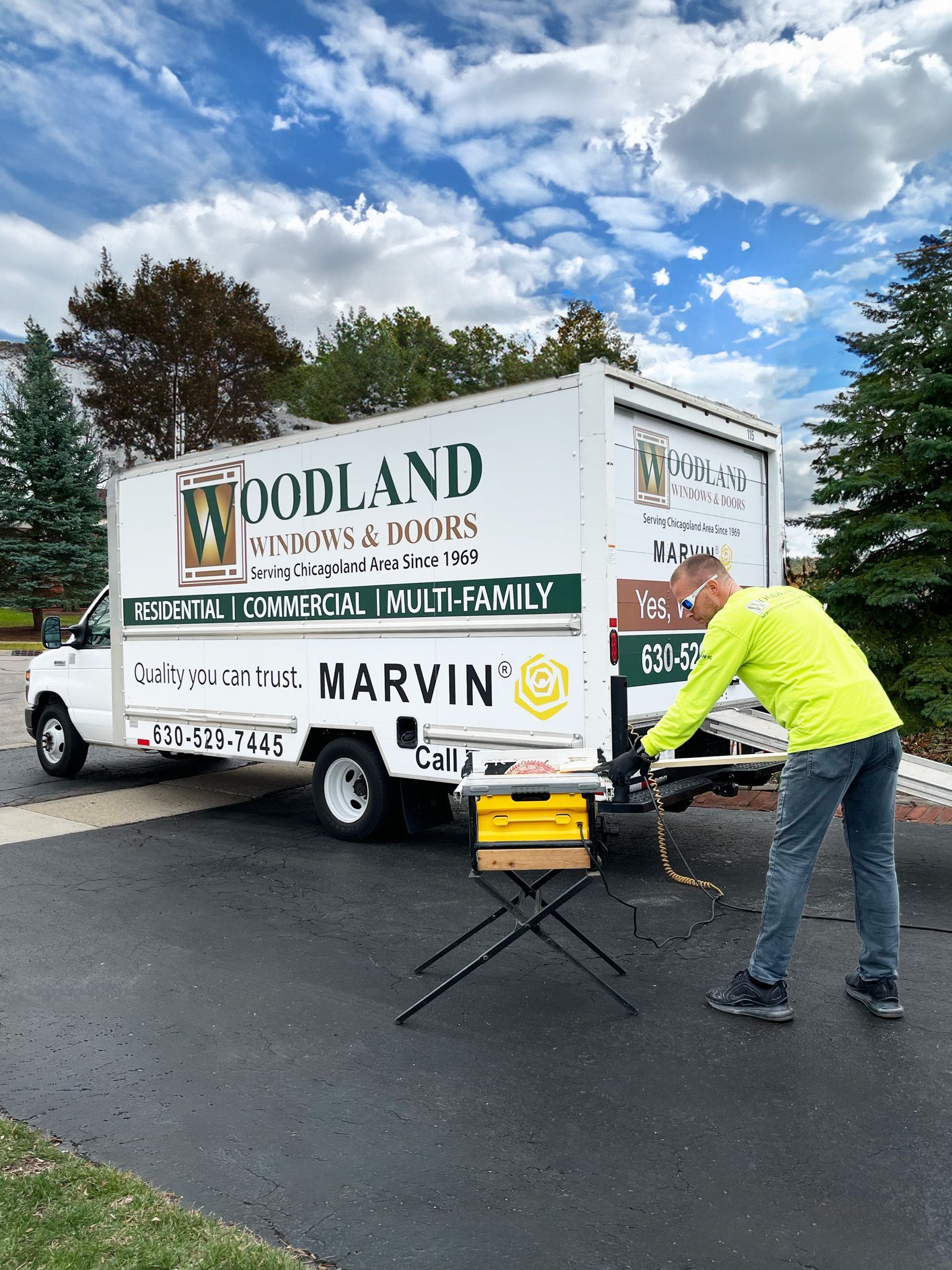 A man is standing in front of a woodland moving truck.