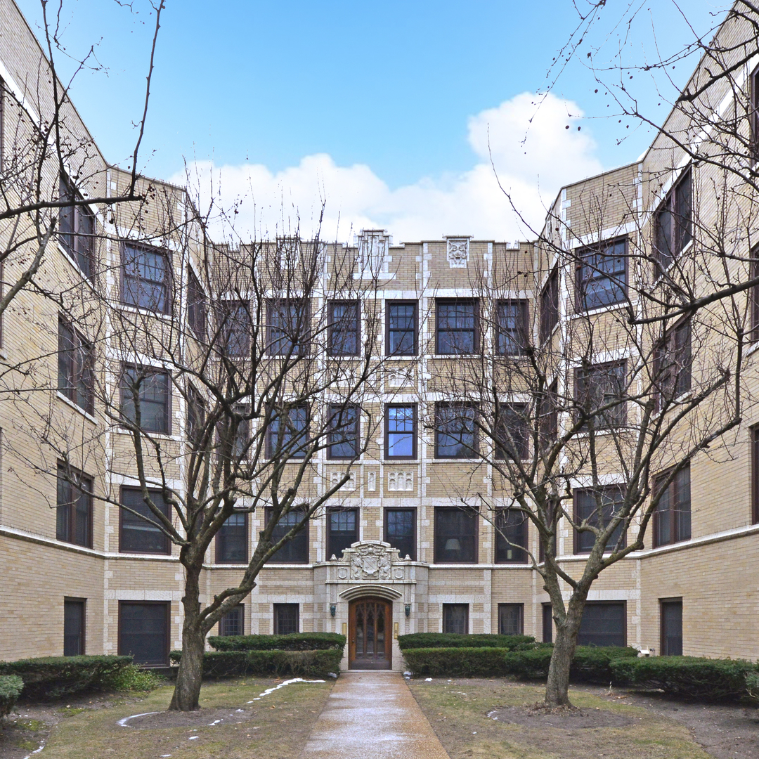 A large building with a lot of windows and trees in front of it